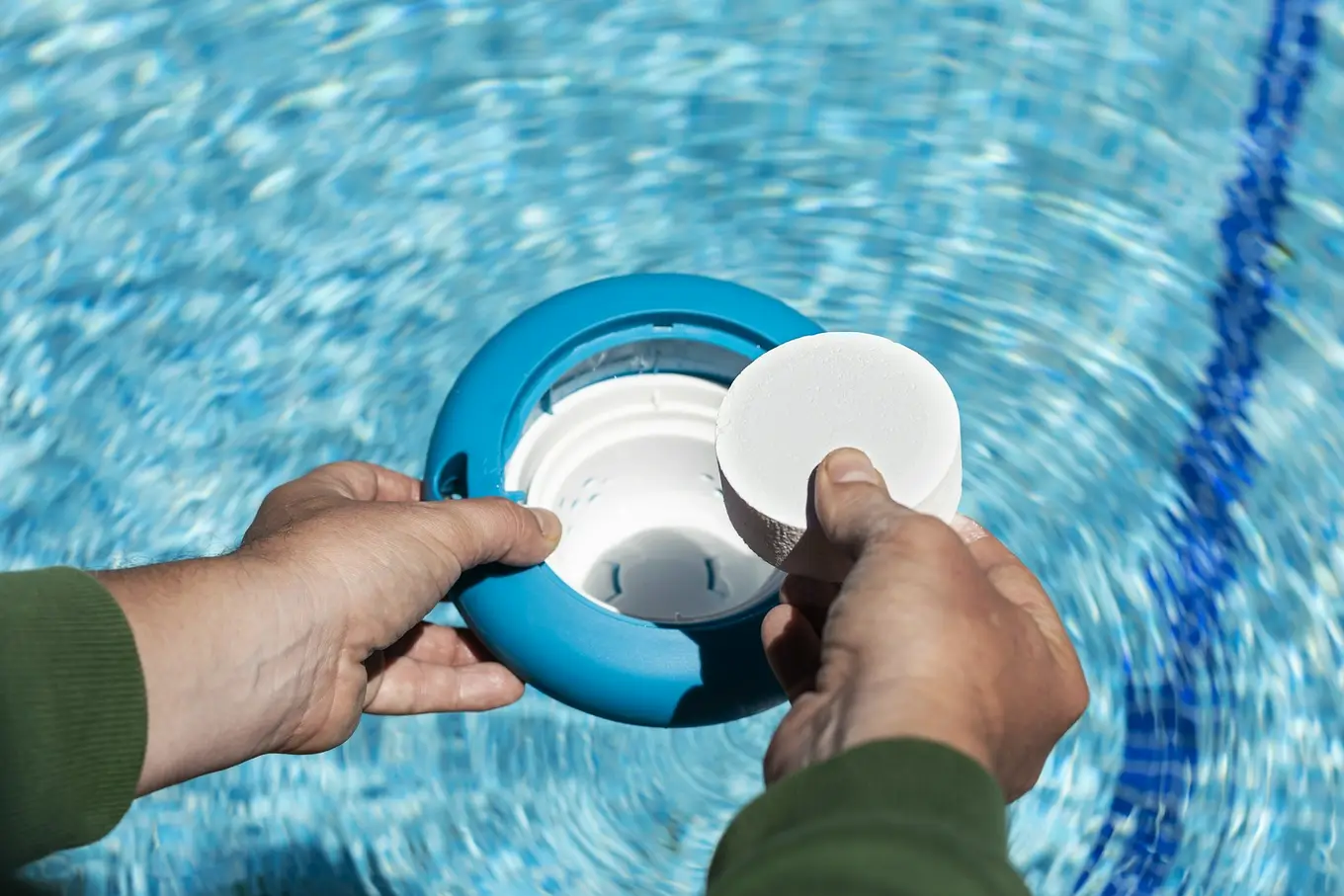 mężczyzna wkłada tabletkę tlenową do filtra do basenu